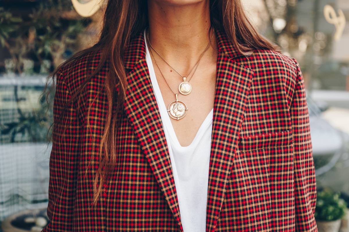Ragazza con giacca blazer e collane in primo piano.