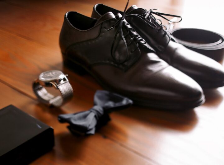 Dettagli di stile maschile: scarpe eleganti, orologio, papillon e cintura.