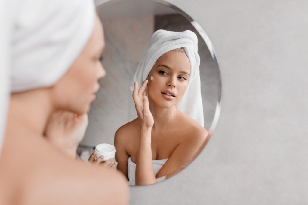 Giovane donna applica crema viso