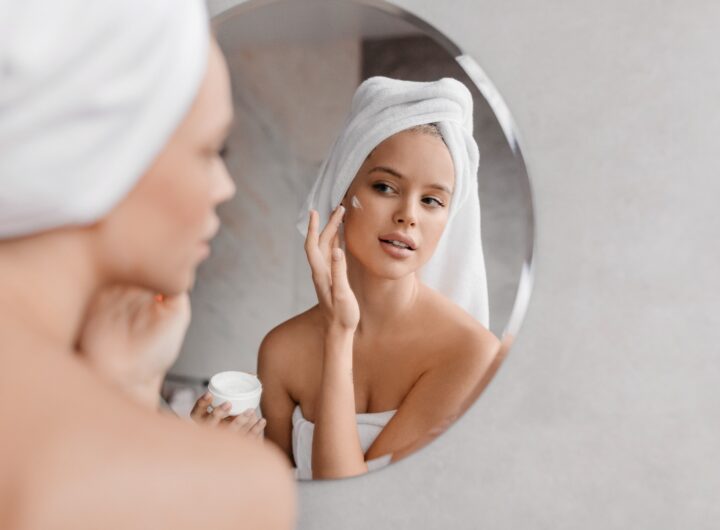 Giovane donna applica crema viso