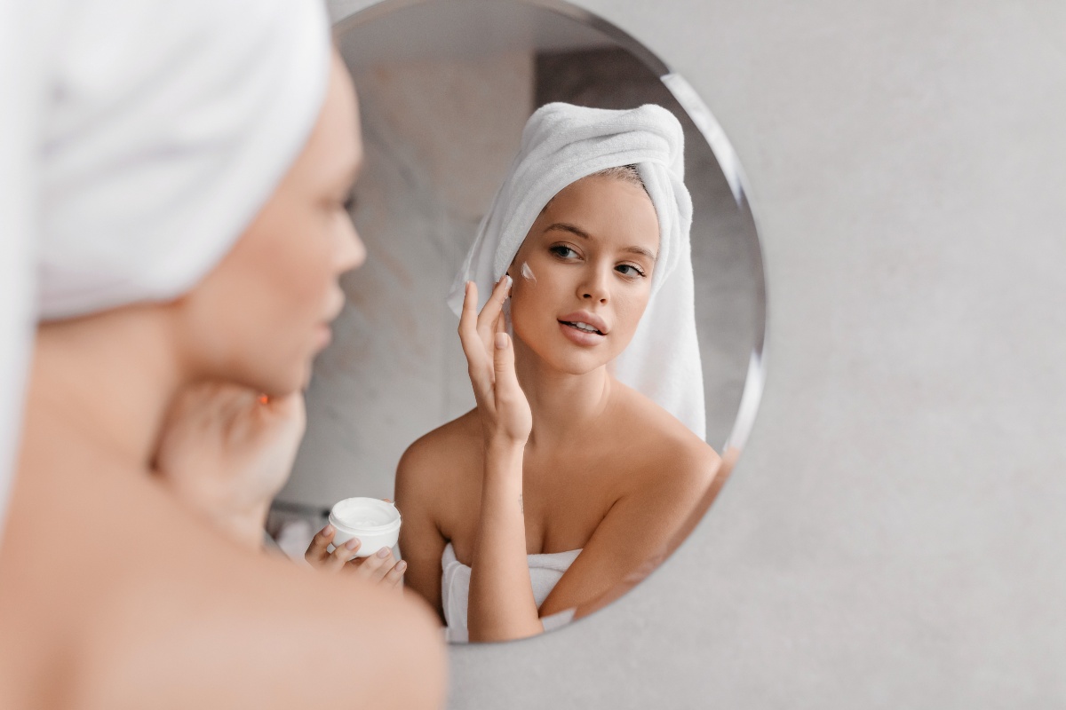 Giovane donna applica crema viso