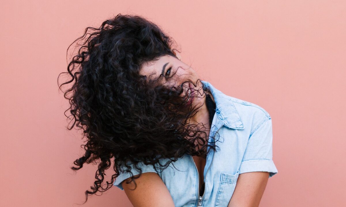 Giovane donna con splendidi capelli ricci