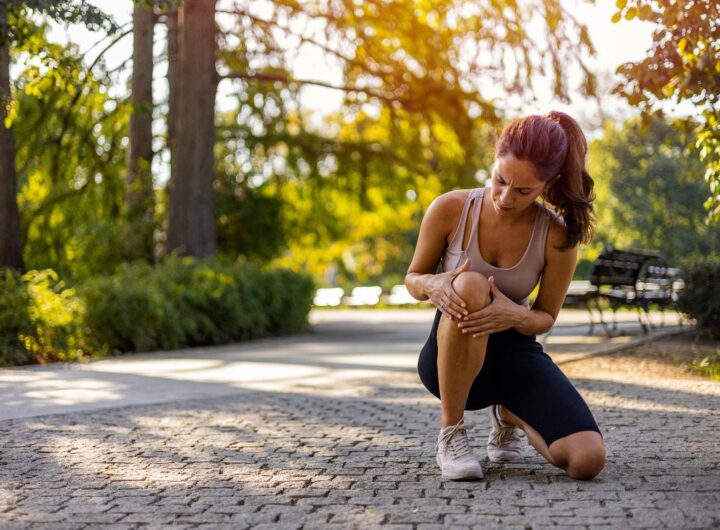 Donna che si ferma durante la corsa a causa di dolore al ginocchio.