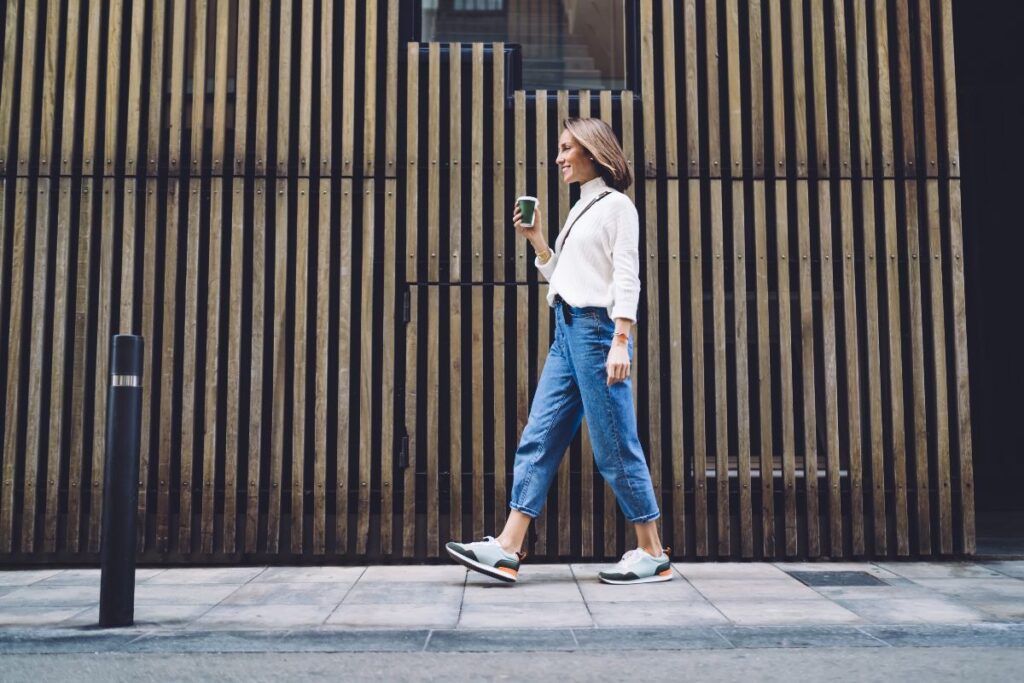 Outfit semplice in città: ragazza cammina indossando jeans e camicia.