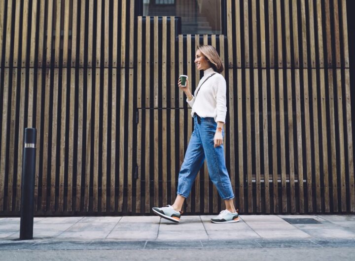 Outfit semplice in città: ragazza cammina indossando jeans e camicia.