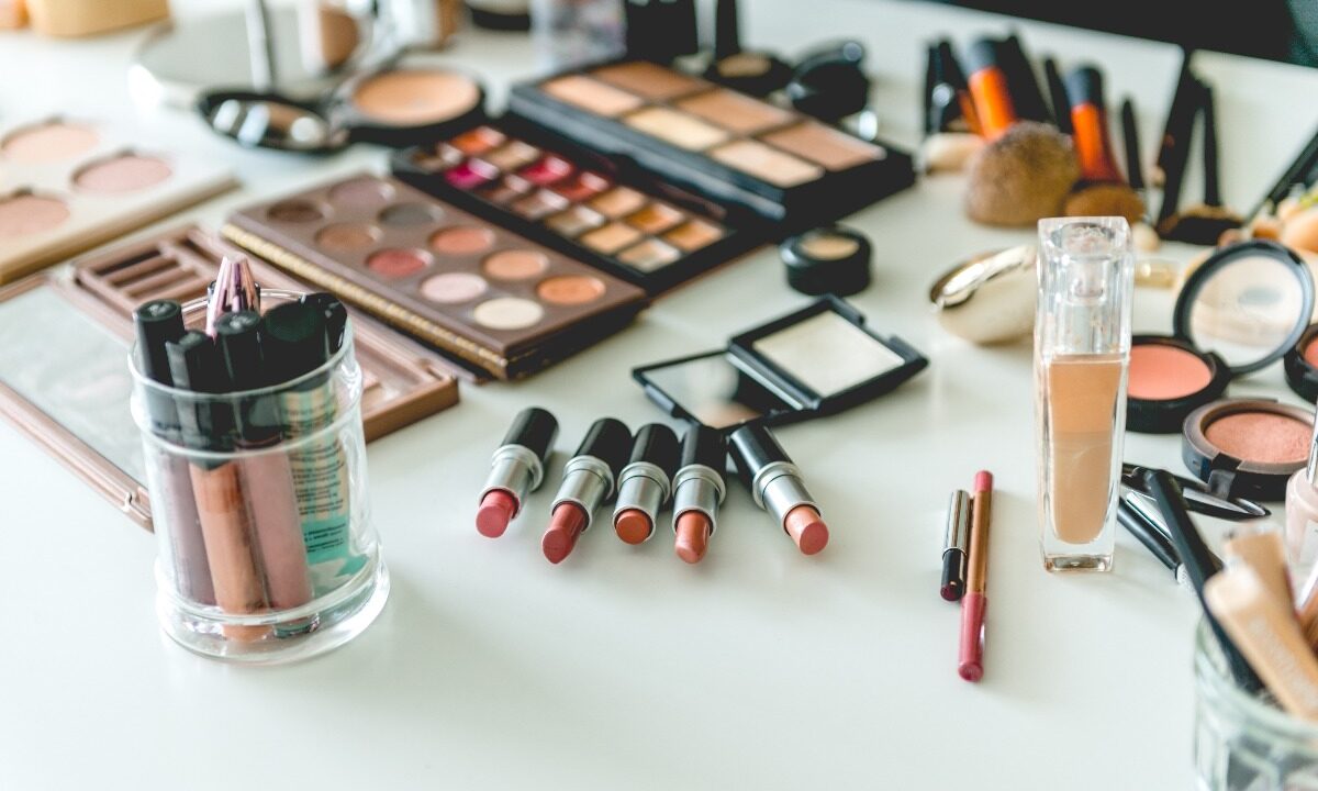 Scrivania bianca con cosmetici assortiti.