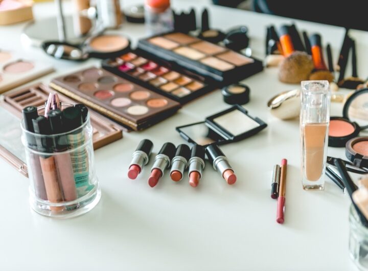Scrivania bianca con cosmetici assortiti.
