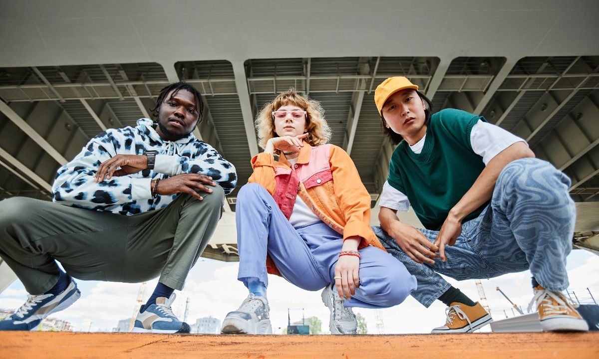 Stile streetwear: tre ragazzi con outfit colorati in stile urbano.