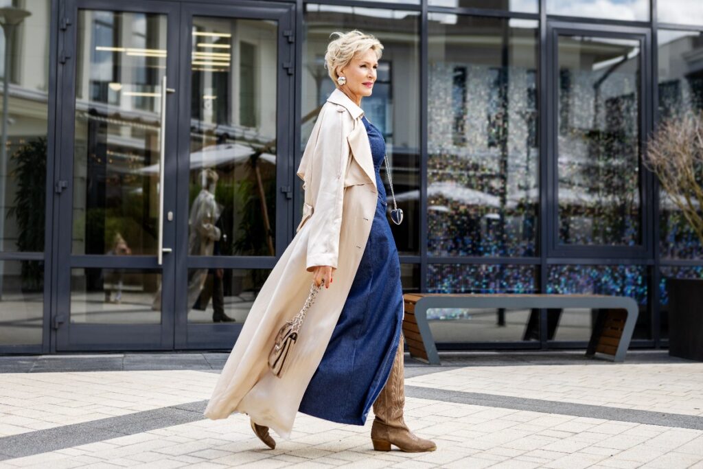 Donna con un raffinato outfit primaverile e trench beige chiaro.