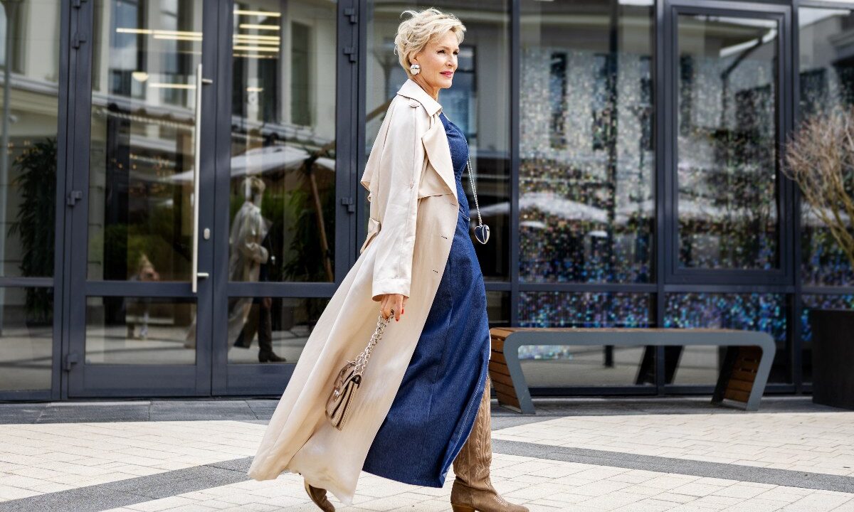 Donna con un raffinato outfit primaverile e trench beige chiaro.